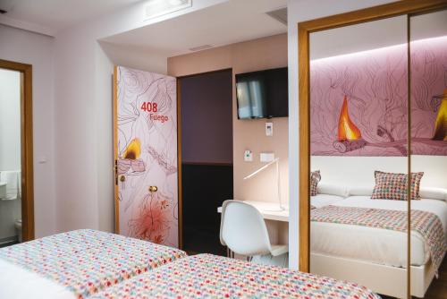 a hotel room with two beds and a desk at Hotel Lino in Vigo