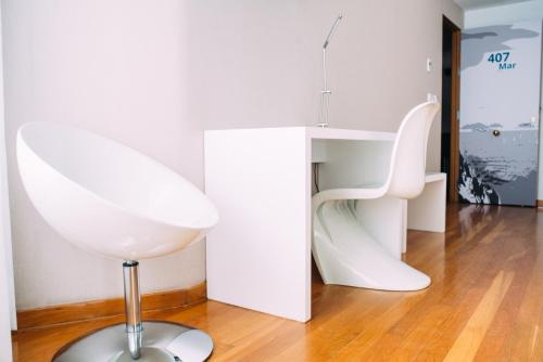 a white chair sitting on a floor in a room at Hotel Lino in Vigo