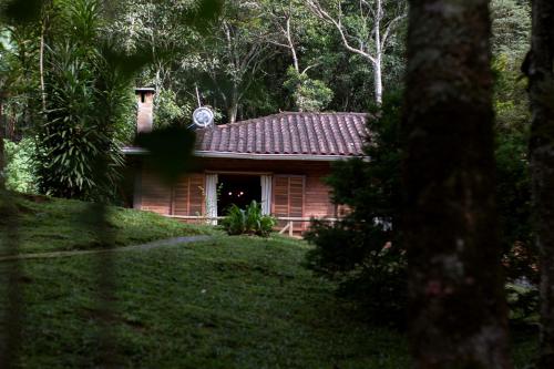 ein kleines Haus inmitten eines Gartens in der Unterkunft Pousada da Carmem in Visconde De Maua
