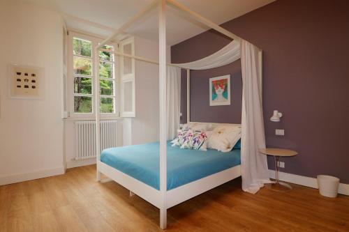 1 dormitorio con cama con dosel y sábanas azules en Royal Cadenabbia, en Cadenabbia