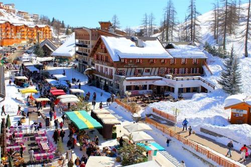 a group of people walking around a market in the snow at Haut de Chalet L'entasse n°9 in Valberg