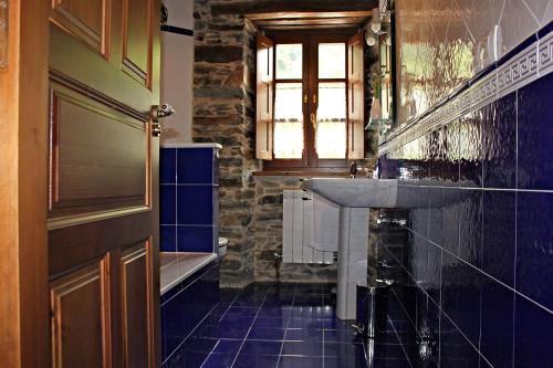 a bathroom with a sink and a tub and a window at Apartamentos El Llago in Boal