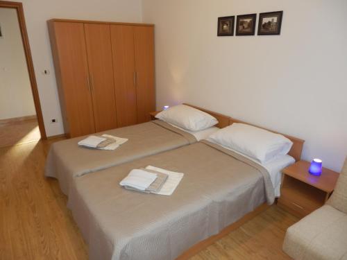 sypialnia z 2 łóżkami i ręcznikami w obiekcie Apartment Greta w mieście Kanfanar