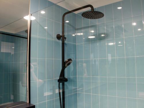 y baño con ducha de azulejos azules. en Apartamento Lapamán, en Bueu