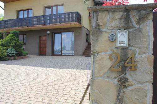 a house with a stone wall with a number on it at Apartament Kapi in Kalwaria Zebrzydowska