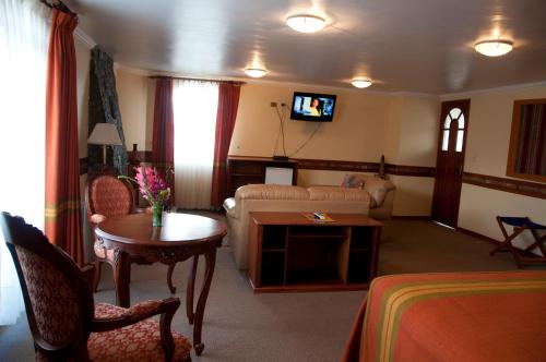 a living room with a couch and a table at Taypikala Lago in Puno