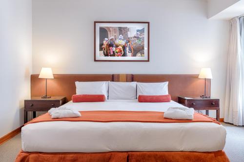 1 dormitorio con 1 cama grande y 2 mesitas de noche en LP Los Portales Hotel Cusco, en Cusco