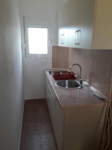 a small kitchen with a sink and a window at Korac Apartments in Ulcinj