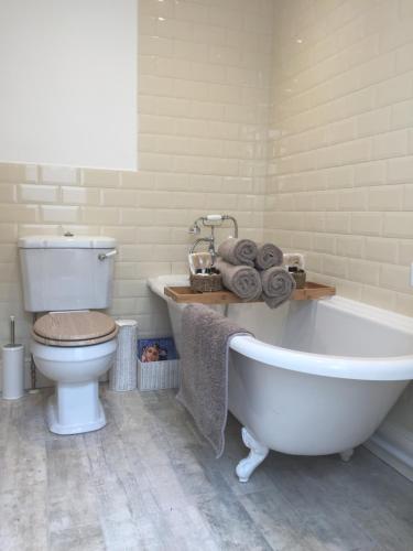 a bathroom with a white tub and a toilet at Barons Granary in Rye