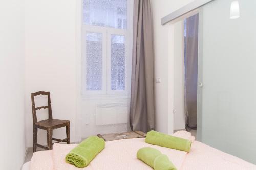 a bedroom with a bed with two green pillows on it at Cozy Apartment Budapest in Budapest