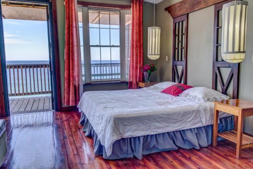 a bedroom with a bed and a balcony at Lands End in West End