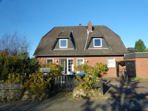 een rood bakstenen huis met een zwart dak bij Ferienwohnung Ochtmissen in Lüneburg