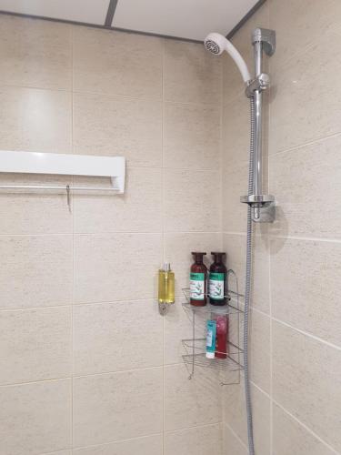 una doccia in bagno con due bottiglie di sapone di Sea Apartment in the Center a Pärnu