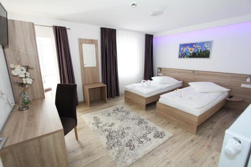 a hotel room with two beds and a table at Pension Villa Colosseo im Herzen von Meiningen in Meiningen