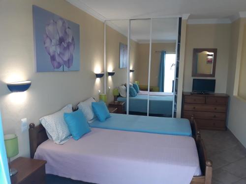 a bedroom with a large bed and a mirror at venha nadar a oura in Albufeira