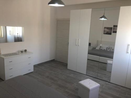 a bathroom with white cabinets and a toilet and a sink at Solemar in Giardina Gallotti