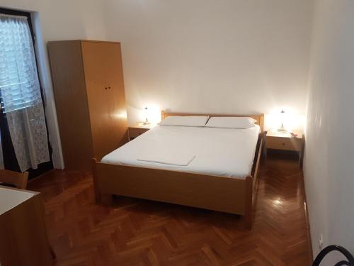 a bedroom with a bed and two lamps on two tables at Apartments Zova in Medulin