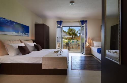 a bedroom with a large bed and a balcony at Caretta Village in Toroni