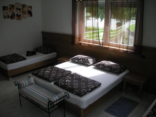 two beds in a room with a window at B&B Il Crocevia in Teglio