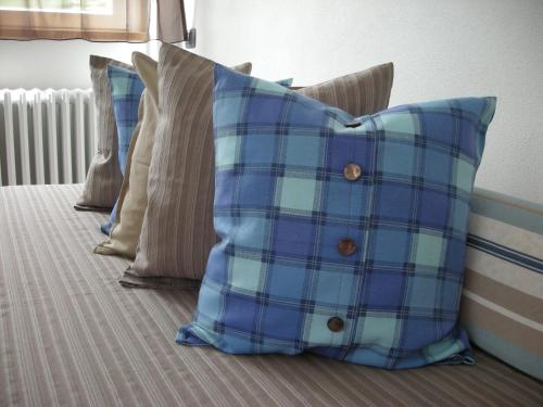 a group of pillows sitting on a bed at B&B Il Crocevia in Teglio