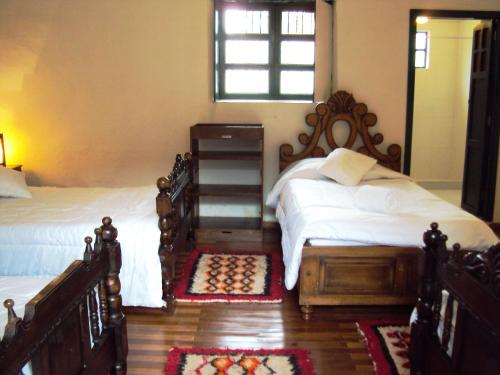 a bedroom with two twin beds and a window at Hotel Hacienda El Aserrio in Iza