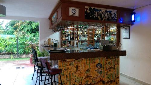 a bar with a counter and chairs in a room at Ecotel Quinta Regia in Valladolid
