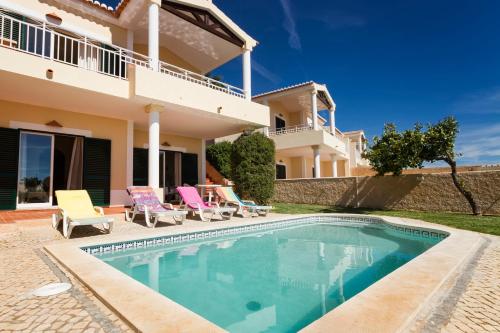 a villa with a swimming pool in front of a house at Villa Acacias 13 in Luz