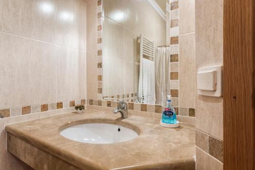 un bagno con lavandino e specchio di Villa Acacias 13 a Luz