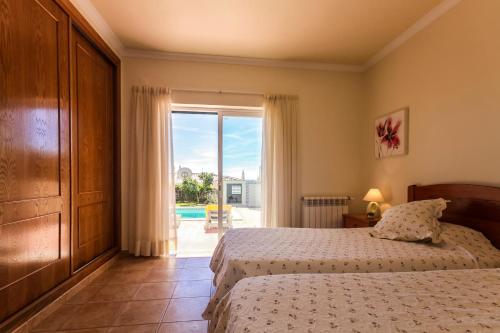 una camera da letto con un letto e una grande finestra di Villa Acacias 13 a Luz