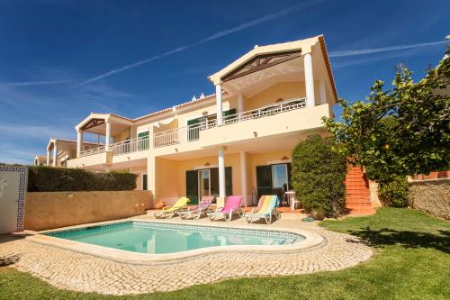 a villa with a swimming pool in front of a house at Villa Acacias 13 in Luz