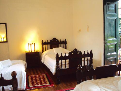 a bedroom with two twin beds and a window at Hotel Hacienda El Aserrio in Iza