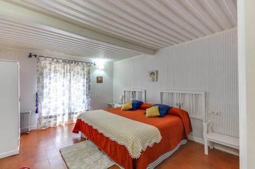 um quarto com uma cama com lençóis laranja e branco em Posada de Los Aceiteros em Ahigal de los Aceiteros