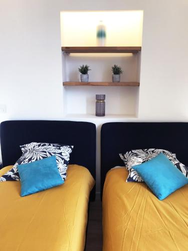 - 2 lits assis l'un à côté de l'autre avec des oreillers dans l'établissement Cannes, à Cannes