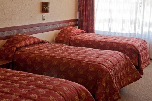 a hotel room with two beds and a window at Taypikala Lago in Puno