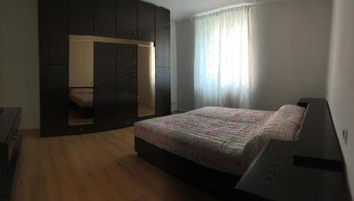 een slaapkamer met een bed, een dressoir en een raam bij Appartamento Duca in Trento