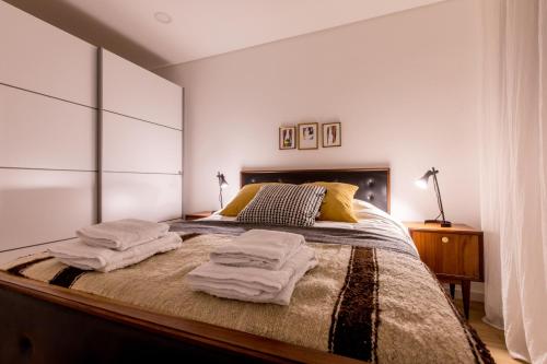 una camera da letto con un grande letto con asciugamani di Casa do Tanque a Arouca