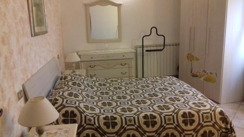 a bedroom with a bed and a dresser and a mirror at Villa L'Oliveto in Trevi