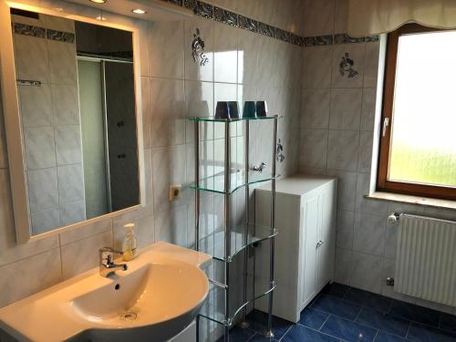 een badkamer met een wastafel en een spiegel bij Urlaub im Zirbenland in Obdach