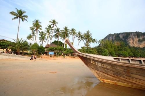 a boat sitting on the shore of a beach at Vacation Village Phra Nang Inn - SHA Extra Plus in Ao Nang Beach