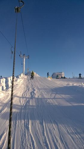 a person is skiing down a snow covered ski lift at The Little Houses in Roybridge