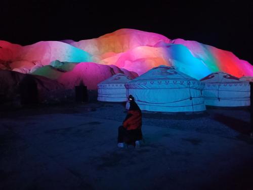 a person standing in front of a display with colorful lights at KaoShan Tent Zhangye in Zhangye