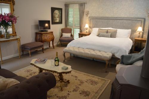 a bedroom with a large bed and a living room at Villa d'Amour in Mount Dandenong