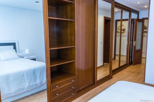 カンガス・デ・オニスにあるApartamento Principadoのベッドの横に木製の本棚が備わるベッドルーム1室
