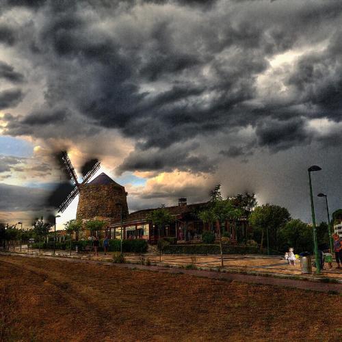 a windmill under a cloudy sky with at Pensión Basagoiti in Getxo