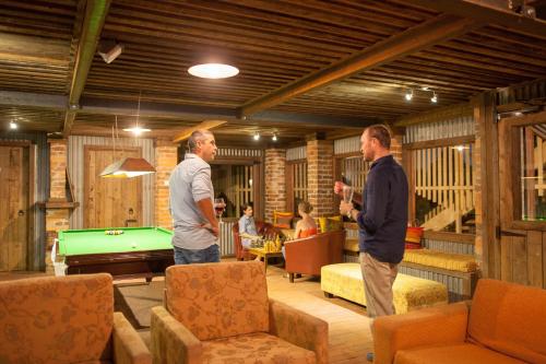 two men standing in a living room with a pool table at Mudgee Homestead Guesthouse in Mudgee
