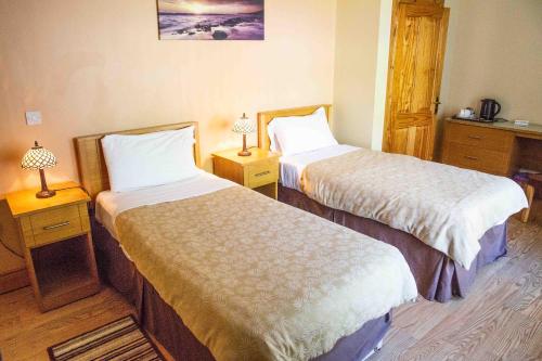 a hotel room with two beds and two lamps at Groarty House/Manor in Derry Londonderry