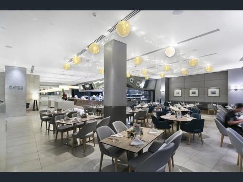 a dining room with tables and chairs and lights at H Star Residences-- Paradise Stayz in Gold Coast