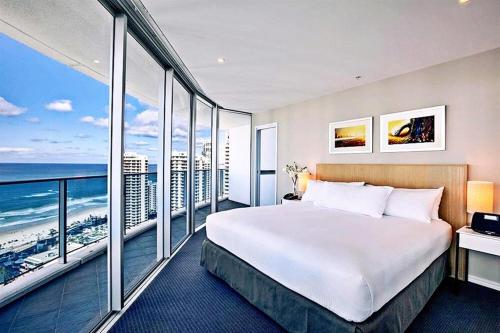 a hotel room with a large bed and large windows at H Star Residences-- Paradise Stayz in Gold Coast