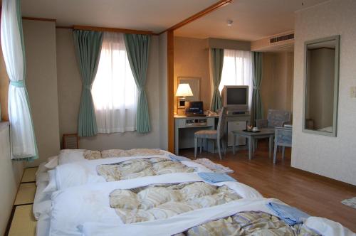 Tempat tidur dalam kamar di Seagrande Shimizu Station Hotel