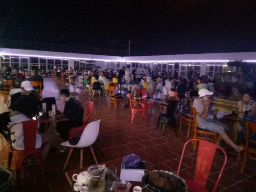 a group of people sitting at tables in a restaurant at night at Sao Kim in Cà Mau